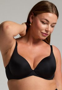 Zwarte gepadde bh met een diepe halslijn, gemaakt van gladde stof. Voorzien van verstelbare bandjes en naadloos ontwerp voor comfort.