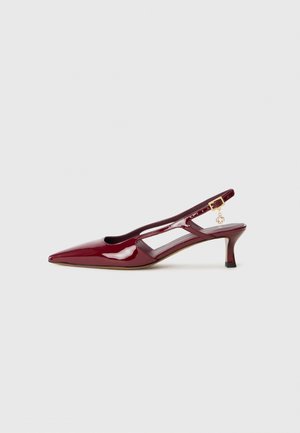 Scarpa slingback in vernice bordeaux con punta affusolata, lati a taglio e tacco sottile; presenta un piccolo charm dorato.