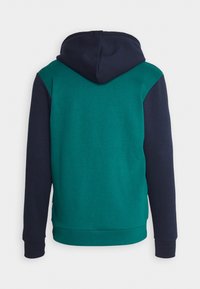 Sudadera con capucha de color verde azulado en el cuerpo y mangas azul marino. Cuenta con un bolsillo tipo canguro, puños y dobladillo acanalados. Textura suave, diseño casual.