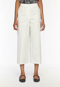 Witte wijde broek met een hoge taille, gemaakt van een soepele stof. Beschikt over een gestructureerd ontwerp en zijzakken.
