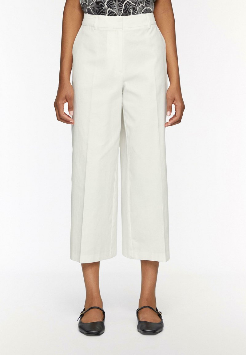 Witte wijde broek met een hoge taille, gemaakt van een soepele stof. Beschikt over een gestructureerd ontwerp en zijzakken.