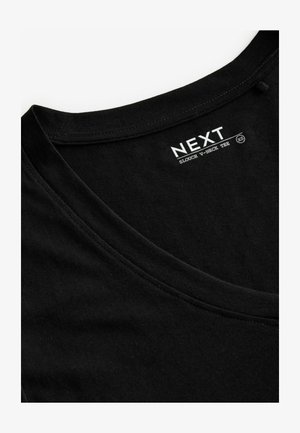 T-shirt nera a scollo a V morbido, realizzata in cotone con una texture liscia, con un'etichetta che riporta la scritta "NEXT" in bianco, taglia XS.