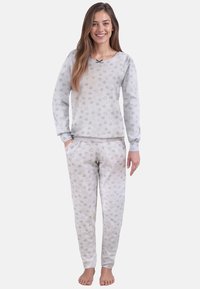 Harmaa pyjamapaketti, johon kuuluu pitkähihainen paita, jossa on syd�änkuvioita ja pieni nauhat yksityiskohta, sekä matching elastiset vyötäröhousut.