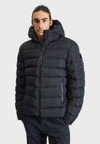 Black puffer jacket with a zip-up front, large hood, and horizontal quilted texture. Features side pockets and subtle branding on the sleeve.
