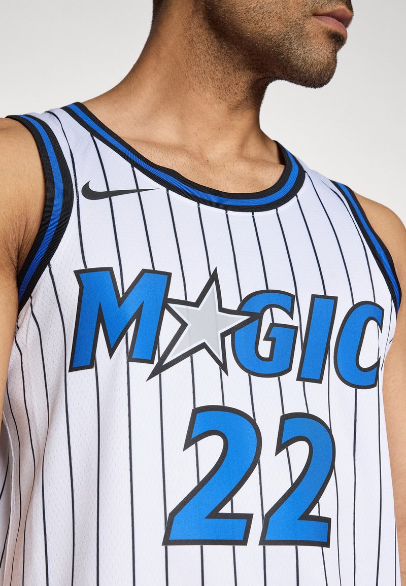 Weißes Basketball-Trikot mit vertikalen schwarzen Streifen. Mit blauem "MAGIC"-Schriftzug, einem silbernen Stern und der Nummer 22. Schwarzer und blauer Rand.