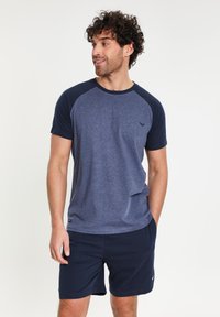 Kurzärmliges T-Shirt in Marineblau und blauer Heather-Optik, runder Ausschnitt, mit strukturierter Oberfläche und dunkelblauen Ärmeln, kombiniert mit Marineblau Shorts mit kleinem Logo.