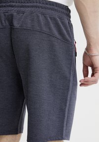 Pánske šortky v tmavosivej farbe s textúrovaným, tkaným dizajnom. Obsahujú elastický pás a bočné vrecká pre praktickosť.