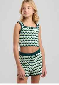 Conjunto de top corto y pantalones cortos con patrón de zigzag en verde y blanco, hecho de material de punto texturizado, con bordes ondulados y cintura con cordón.
