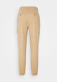 Beiga cargobyxor med elastisk midja, smalnade anklar, två sidofickor och två bakfickor med knäppningar. Slätt tyg i bomullsblandning.