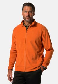 Orange fleece jacket with a high collar, front zipper, and side pockets. Textured fabric visible; smooth finish, rugged design.