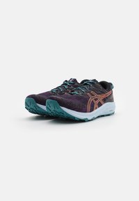 Baskets de trail de course violettes avec des accents teal, un dessus texturé et une semelle extérieure blanche présentant un motif de grip pour une meilleure traction.