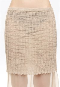 Falda de punto beige con un patrón texturizado, tejido ligero, dobladillo con forma de ondulación y una cintura ajustada. Capa inferior transparente visible.