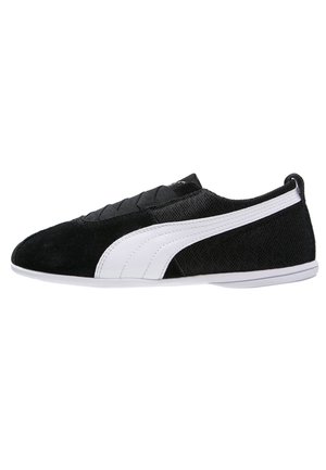 Nízkoprofilová černá teniska s bílým proužkem, materiály z plsti a semiše a bílou podrážkou, zobrazena z boku.