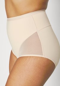 Shapewear a vita alta in tessuto beige con una superficie liscia, dotato di pannelli in rete sui lati per una migliore traspirazione.