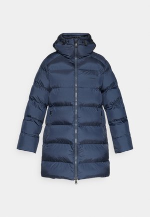 Tummansininen puhvitakki, jossa on vetoketjukiinnitys, joustavat hihansuut ja säädettävä huppu. Ominaisuuksiin kuuluu vaakasuorat tikatut rakenteet eristykselle.