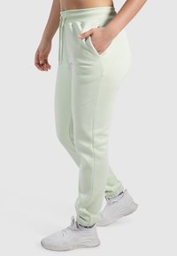 Ljusgröna sweatpants i mjuk bomullsblandning, med sidorfickor, dragsko i midjan och ribbade mudd för en snug passform.