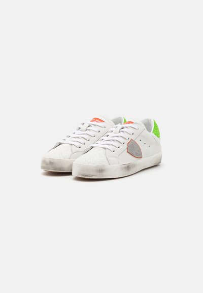 Valged nahast sneakers, millel on tekstureeritud varvasetõstuk, erekollane tagapaneel ja oranž logo. Lame tallaga, millel on kerge kulumine.