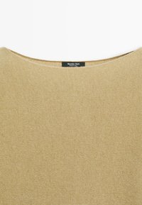 Beżowy sweter dzianinowy z okrągłym dekoltem i czarną metką z napisem "Massimo Dutti Made in China" przy kołnierzu z tyłu.