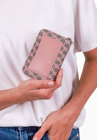 Peněženka na zip, šedá tkanina s růžovým cik-cak vzorem, jednolitý růžový akcent, kovový detail loga, obdélníkový tvar, kompaktní velikost, texturovaný povrch.