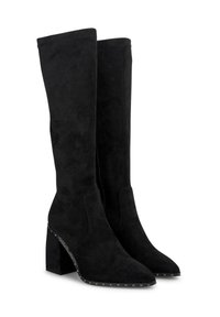 Botas de ante negras hasta la rodilla con punta afilada, tacón grueso y detalles de tachuelas a lo largo de la suela. Textura suave y diseño ajustado.