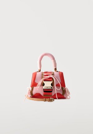 Small handbag with pink mesh, red leather accents, thick wrapped pink handle, large front buckle, and a tan adjustable strap.