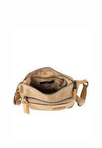 Bolsa de lona beige con detalles en cuero marrón claro, compartimentos con cremallera e interior estampado. Correa ajustable para llevar de forma versátil.