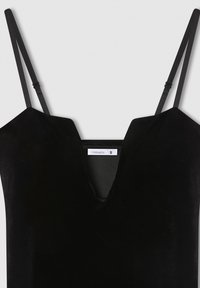 Czarny aksamitny top bez rękawów z regulowanymi cienkimi ramiączkami i głębokim dekoltem w kształcie litery V, rozmiar mały, metka widoczna wewnątrz.
