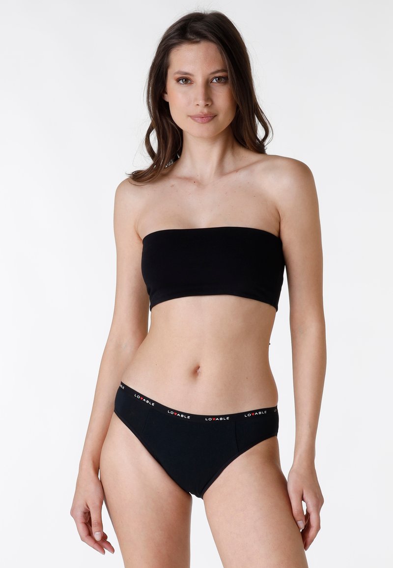 Bandeau nero e bikini abbinato con fascia logo rossa e bianca. Tessuto liscio e elasticizzato con cuciture minime e senza dettagli aggiuntivi.