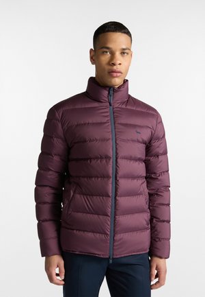 Gevoerde bordeauxjack met hoge kraag, verticale stiksels, ritssluiting en zijzakken. Voorzien van een klein logo op de borst.