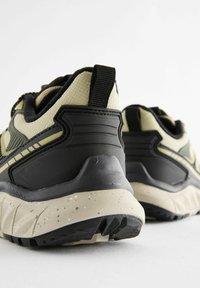 Wielokolorowe sneakersy z czarną i oliwkową górą, teksturowaną siateczką i gumowymi akcentami, amortyzowaną podeszwą z nakrapianymi detalami oraz tylną pętelką do zakupu.