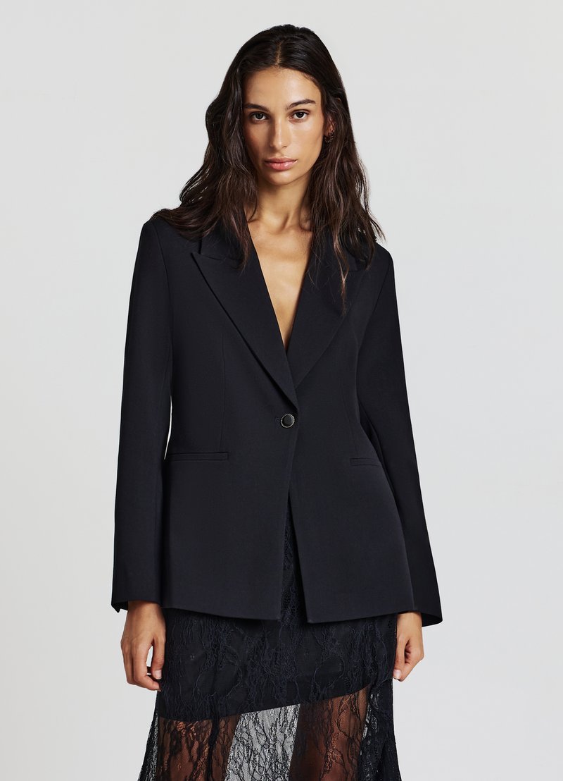 Schwarzer Blazer mit kurzem Revers, Ein-Knopf-Verschluss, zwei Fronttaschen und langen Ärmeln. Glatter Stoff mit figurbetontem Schnitt.