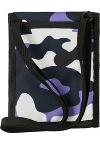 Kamikaze crossbody taška vyrobená z odolnej látky. Disponuje čiernou, bielou a fialovou farebnou schémou, nastaviteľným popruhom a zipsovým uzáverom.