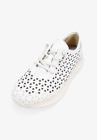 Zapatilla blanca perforada que presenta un diseño de recortes geométricos, cordones texturizados y una suela de goma flexible para una mayor transpirabilidad.