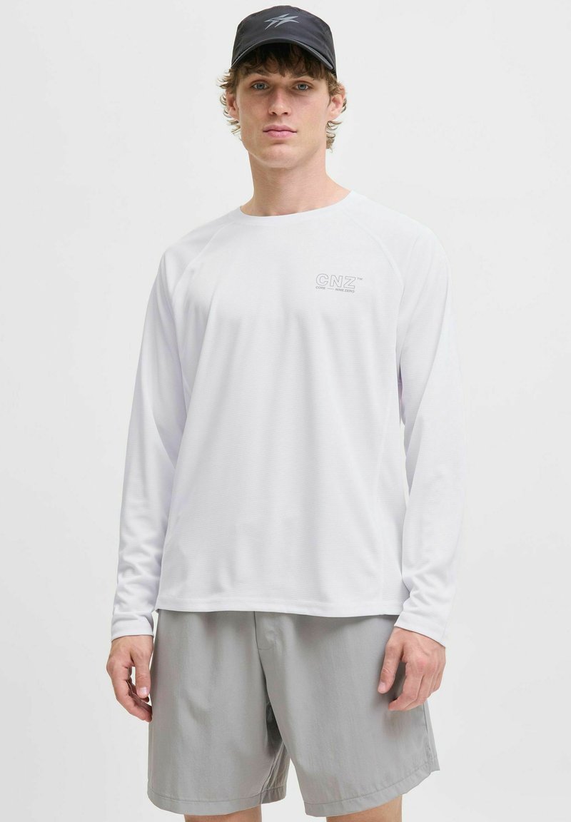 Wit sportshirt met lange mouwen van textuurstof en het 'CNZ'-logo op de borst, gecombineerd met lichtgrijze shorts.