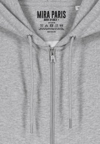 Felpa grigia con zip realizzata in 100% cotone. Presenta una zip YKK, lacci con terminali in argento e un'etichetta del marchio stampata all'interno del colletto.