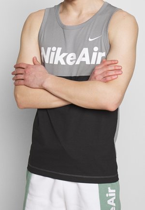 Le tank top sans manches gris et noir de NikeAir présente un logo audacieux sur la poitrine, fabriqué à partir d'un tissu lisse et léger.