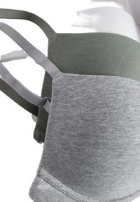 Tres sujetadores sin costuras en gris, verde oliva y blanco. Cuentan con una tela suave, tirantes ajustables y una textura lisa sin adornos añadidos.