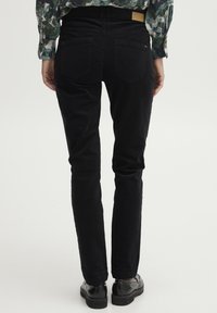 Black cotton trousers with a slim fit, featuring a waistband label, two back pockets, and a smooth, textured fabric.