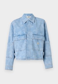 Veste en denim bleu clair avec un motif floral, manches longues, deux poches avant et un col pointu. Design cropped avec des coutures visibles.