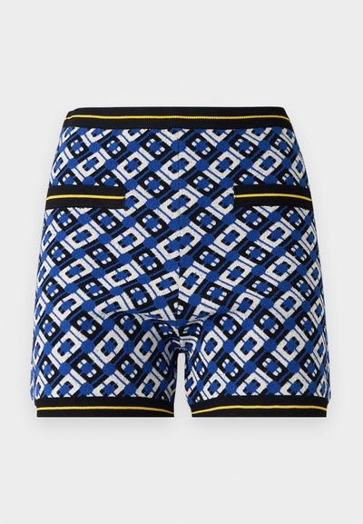 Shorts en tricot à motifs présentant un design géométrique bleu, noir et blanc, avec des accents jaunes contrastés et des poches sur les côtés.