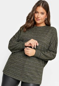 Mörkgrön och svart randig tröja med en avslappnad passform, rund halsringning och långa ärmar. Texturerad stickad tyg med lätt lyster.