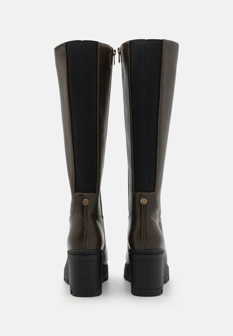 Bottes en cuir marron montantes avec des panneaux latéraux élastiques, un bout carré et un talon épais noir ; elles possèdent une fermeture éclair et des éléments décoratifs.