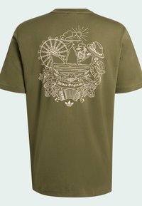 Olívovo zelené bavlnené tričko s veľkou svetlou grafikou na chrbte, zobrazujúcou rôzne ikony a text "Adidas Originals."