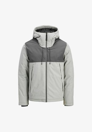 Giacca grigia chiara con una parte superiore grigia scura, cappuccio, chiusura frontale con zip e polsini elastici. Tessuto liscio con una consistenza leggermente imbottita.