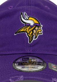 Purple adjustable cap featuring an embroidered viking design in yellow and black. Includes a circular New Era label on the brim.