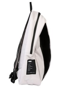 Sac à dos blanc Puma avec fermeture éclair noire, poche latérale et écusson logo, montré de côté avec des bretelles rembourrées.