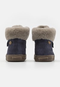 Marinblå mocka ankboots med en ljusgrå fuskpälskrage och kardborreband, med gummisulor och texturerad yta för bra grepp.