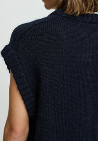 Marineblauer gestrickter Pullover mit kurzen umgeschlagenen Ärmeln und Rippdetails an den Bündchen und am Halsausschnitt. Weiches, strukturiertes Gewebe.