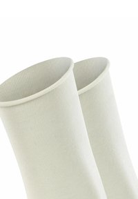 Beige geribbelde sokken met een gladde textuur en een brede manchet aan de bovenkant, ontworpen voor comfort en flexibiliteit.