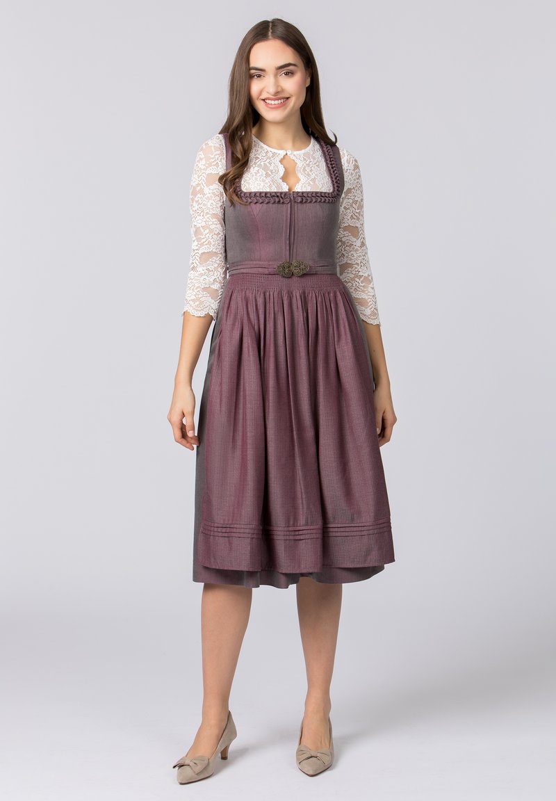Traditionelles Dirndl mit einem taillierten burgunderfarbenen Mieder, einem gefalteten Rock, Spitzenärmeln und einer dekorativen silbernen Brosche an der Taille.